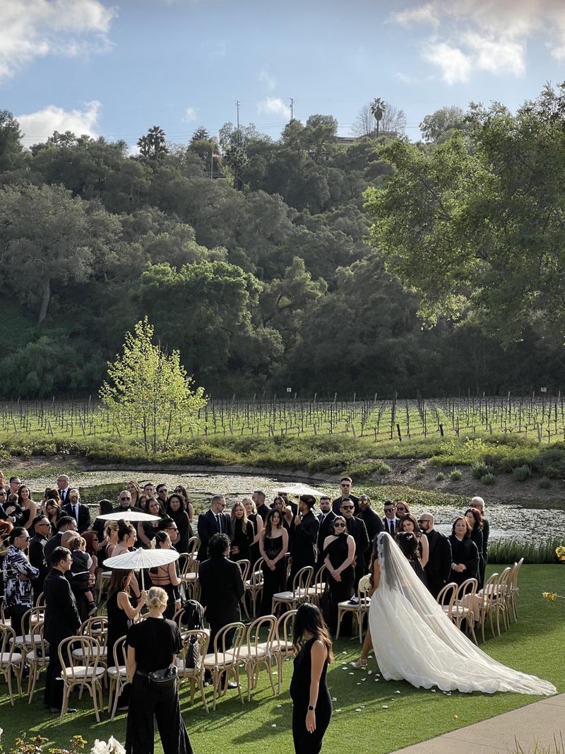Bride walking down the aisle at an outdoor vineyard wedding ceremony